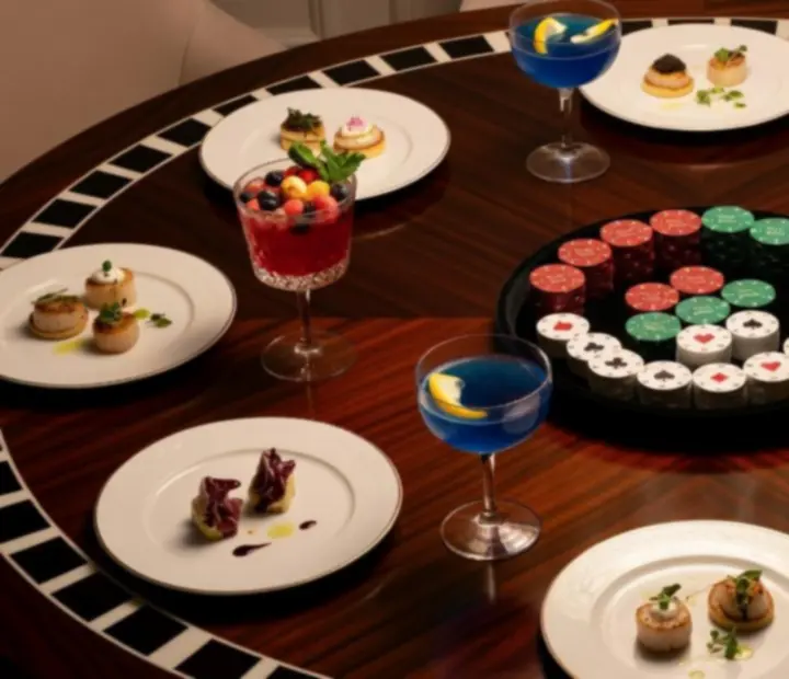 Pokerowy stół ze szklankami koktajli i wykwintnymi daniami degustacyjnymi